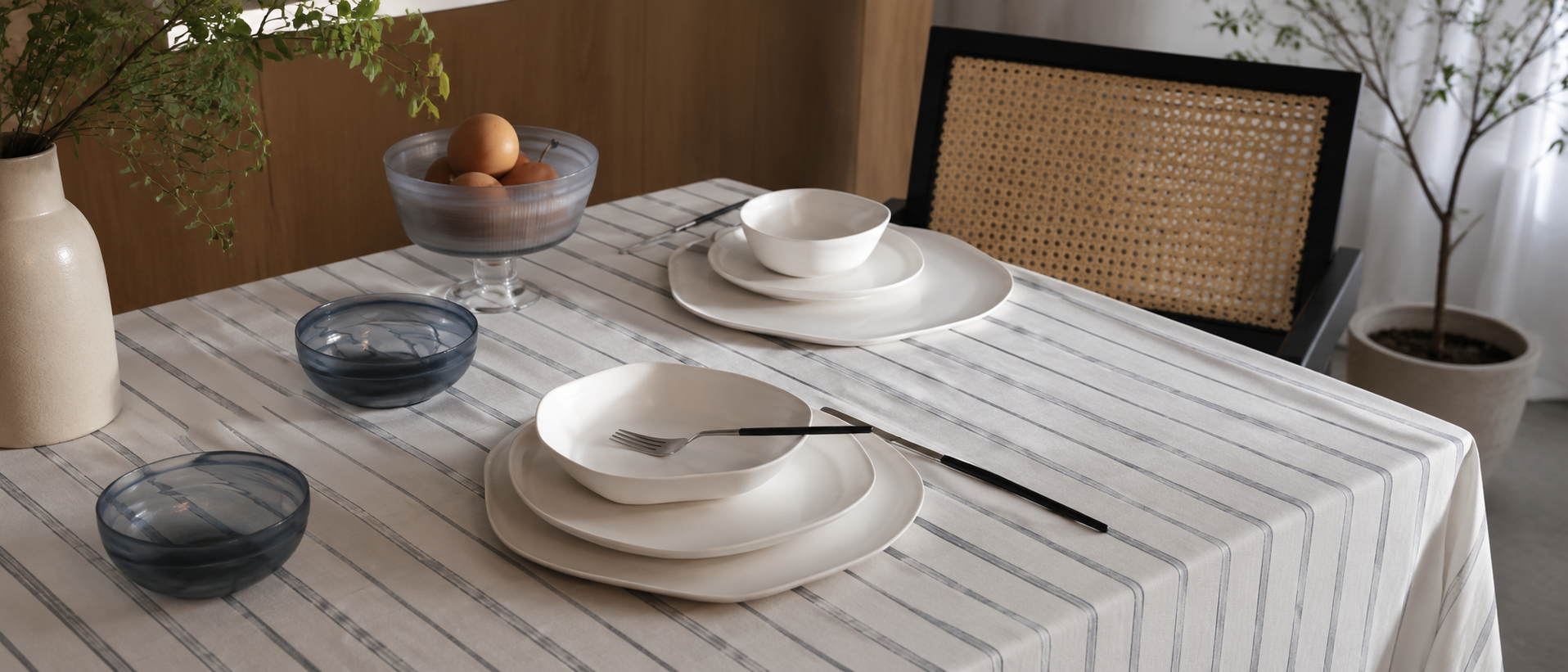 A thoughtfully arranged dining table with modern plates and tableware